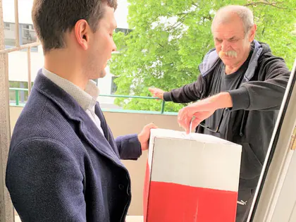 Mieszkaniec wrzuca kartę do urny na balkonie