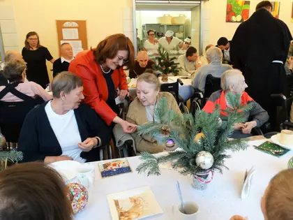 Mieszkańcy, pracownicy i goście przy wigilijnym stole ze stroikiem z gałązek