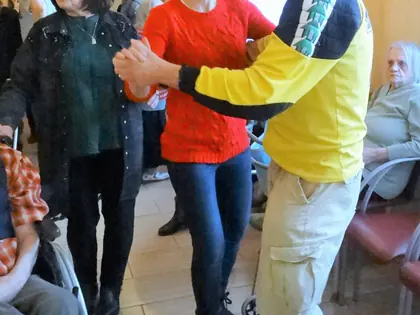 Mieszkaniec tańczy z kobietą w czerwonej bluzce