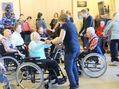 Opiekunki tańczą z mieszkańcami na wózkach podczas karnawału