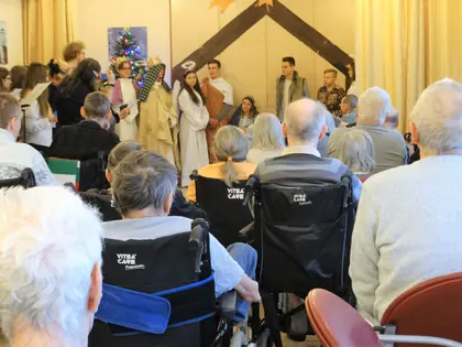 Mieszkańcy na wózkach oglądają jasełka w świetlicy