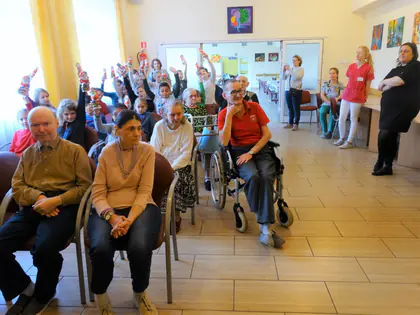 Mieszkańcy podnoszą ręce podczas występu dzieci
