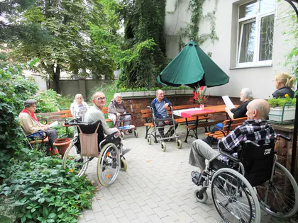 Mieszkańcy zebrani w ogrodzie Domu podczas uroczystości rocznicowej