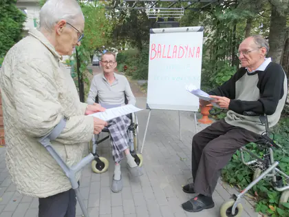 Trzech mieszkańców czyta role z Balladyny w ogrodzie