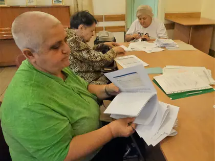 Mieszkanki porządkują dokumenty przy stole