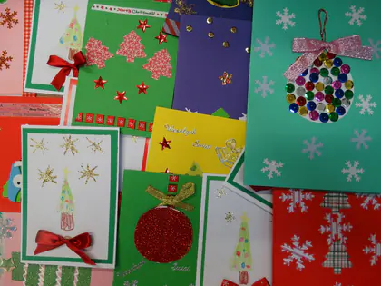 Ręcznie wykonane kartki świąteczne od uczniów z choinkami, bombkami i gwiazdami