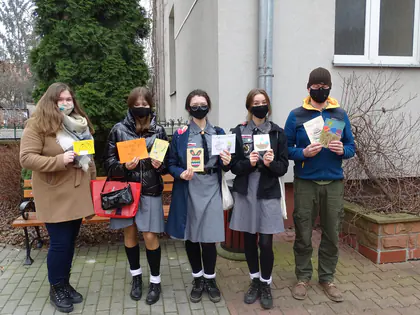 Harcerki w maseczkach pokazują własnoręcznie wykonane kartki wielkanocne