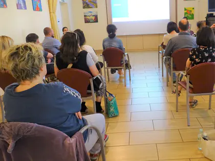 Uczestnicy szkolenia siedzą w rzędach przed ekranem