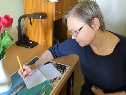 Mieszkanka pisze list przy biurku z tulipanami