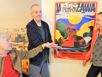 Mieszkańcy oglądają plakat z napisem Warszawa, stolica wolnego czasu