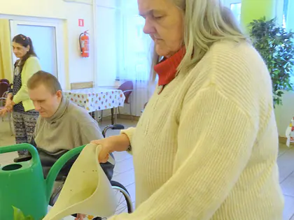 Mieszkanka podlewa rośliny konewką