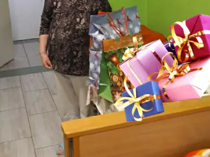 Mieszkanka trzyma stos świątecznych prezentów