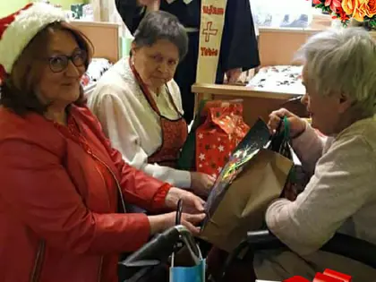 Zakonnik i goście rozdają prezenty mieszkańcom w świetlicy