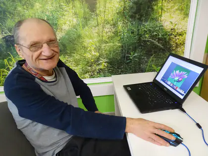 Uśmiechnięty mieszkaniec przy laptopie z myszką
