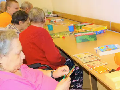 Mieszkanki układają klocki i gry przy stole
