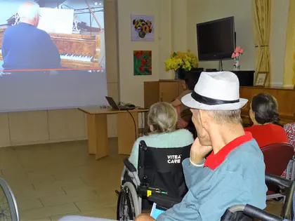 Mieszkańcy oglądają transmisję koncertu fortepianowego na ekranie