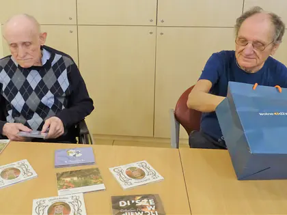 Dwaj mieszkańcy przy stole z płytami i torbą z prezentami