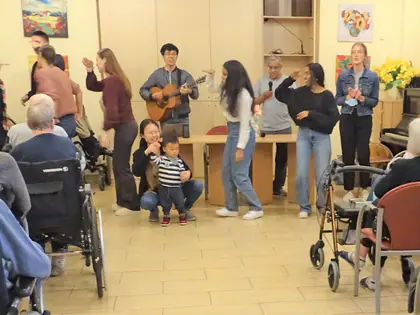 Wolontariusze tańczą i grają na gitarze przed mieszkańcami