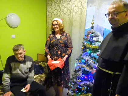 Mieszkaniec, pracownica i zakonnik przy choince w pokoju