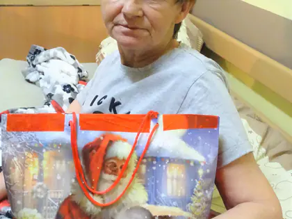 Mieszkanka trzyma świąteczną torbę z Mikołajem