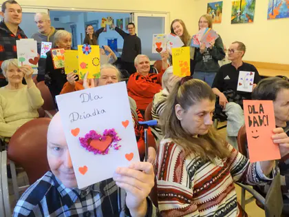 Mieszkańcy unoszą kartki z napisami Dla Dziadka i Dla Babci
