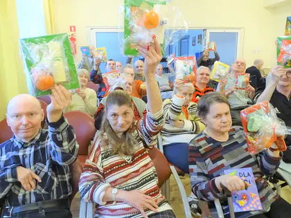 Mieszkańcy unoszą prezenty od młodzieży