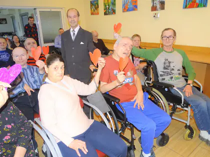 Mieszkańcy z papierowymi sercami pozują w świetlicy w walentynki