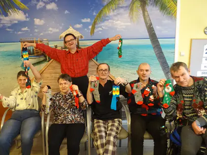 Mieszkańcy z kolorowymi niedopasowanymi skarpetkami pozują przed fototapetą