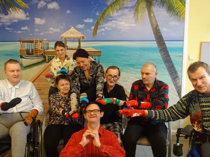 Mieszkańcy pokazują kolorowe skarpetki na tle fototapety z plażą