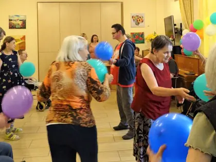 Mieszkańcy bawią się kolorowymi balonami w świetlicy