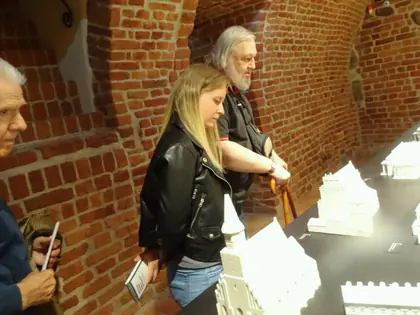 Mieszkańcy oglądają makietę miasta w ceglanych wnętrzach muzeum