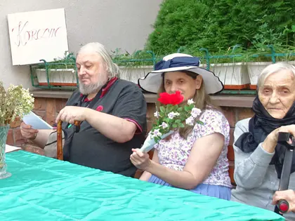 Mieszkańcy w strojach z epoki czytają przy stole z wazonem kwiatów podczas Narodowego Czytania