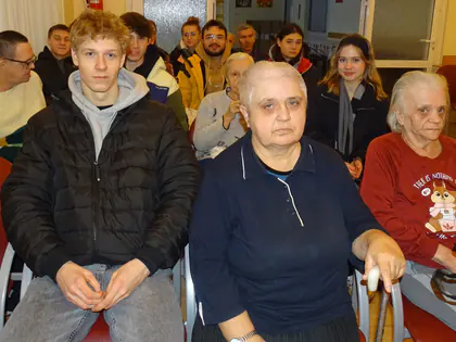 Mieszkańcy i młodzież siedzą razem w świetlicy