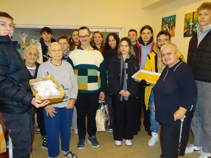 Młodzież i mieszkańcy z tacą szarlotki pozują w świetlicy