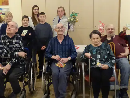 Mieszkańcy i dzieci pozują w świetlicy z pierniczkami
