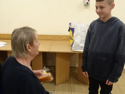 Chłopiec wręcza piernik mieszkance