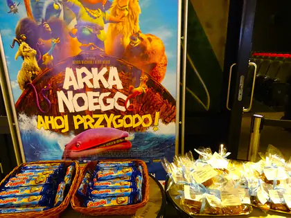 Plakat filmu Arka Noego, Ahoj przygodo!, pod nim kosze z ciastkami i upominkami