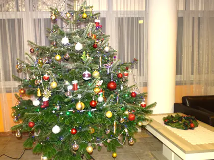 Ubrana choinka z bombkami i łańcuchami w jasnym holu