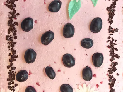Różowy tort z jagodami i stokrotkami na brzegach