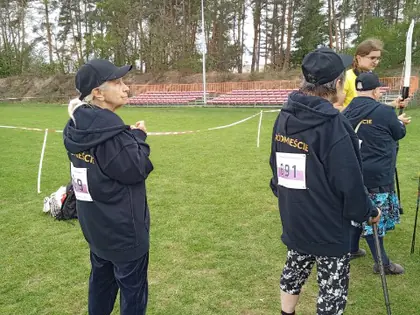 Seniorzy strzelają z łuku na boisku podczas olimpiady