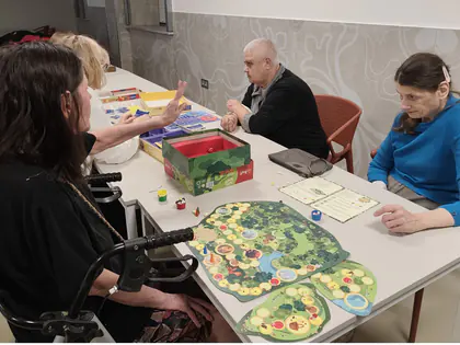 Mieszkańcy grają w grę planszową przy stole