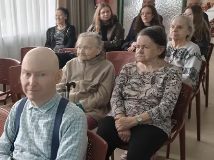 Mieszkańcy słuchają prezentacji siedząc w rzędach
