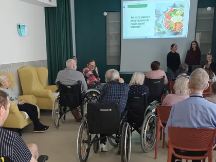 Słuchacze siedzą na sali, na ekranie slajd o zdrowym odżywianiu, przy ekranie stoją dwie prelegentki