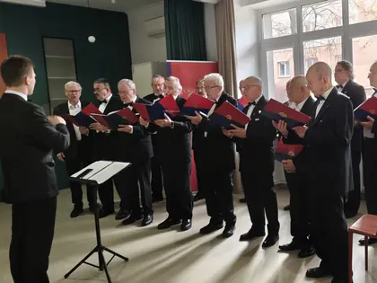 Chór śpiewa pieśni patriotyczne przed mieszkańcami