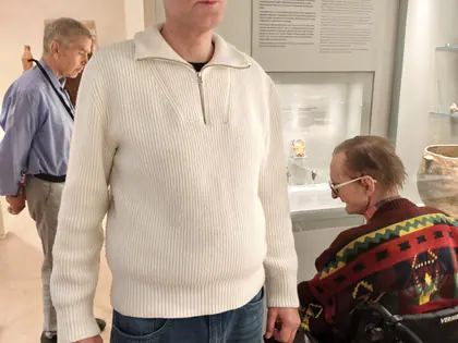 Mieszkaniec w białym swetrze i mieszkanka na wózku w muzeum