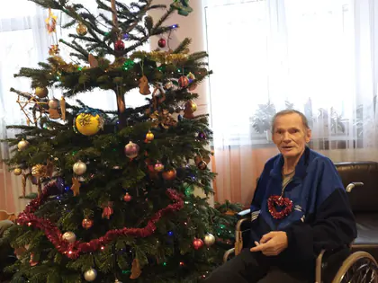 Mieszkaniec na wózku przy ubranej choince