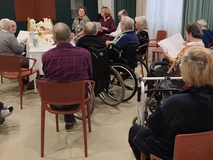 Mieszkańcy siedzą w świetlicy podczas spotkania wigilijnego