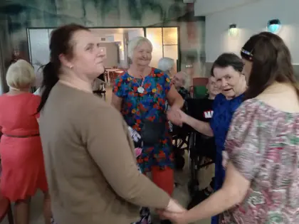 Mieszkanki tańczą trzymając się za ręce