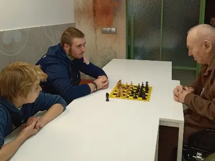 Chłopcy grają w szachy z mieszkańcem
