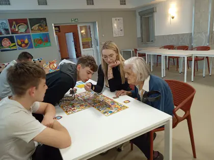 Młodzież i mieszkanka grają w grę przy stole
